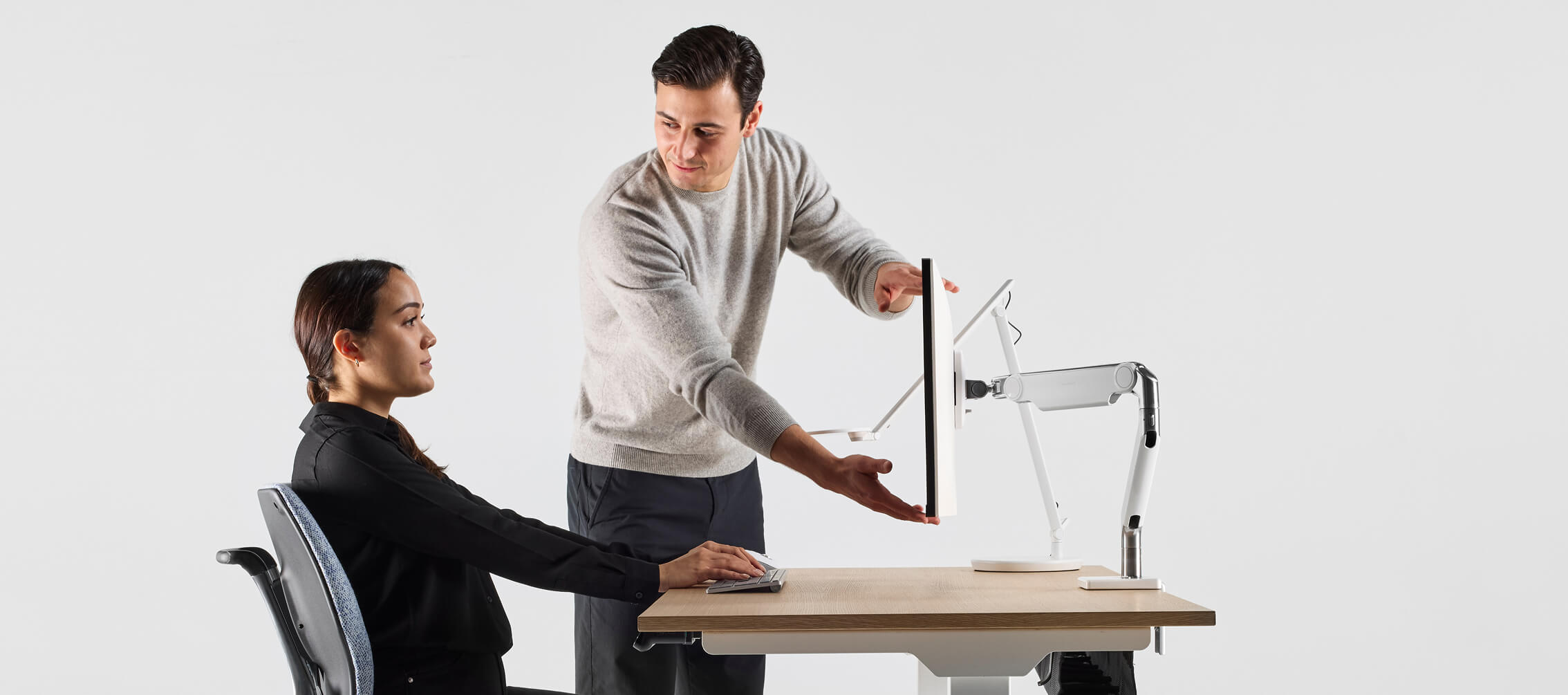 woman having her monitor adjusted for peak ergonomics