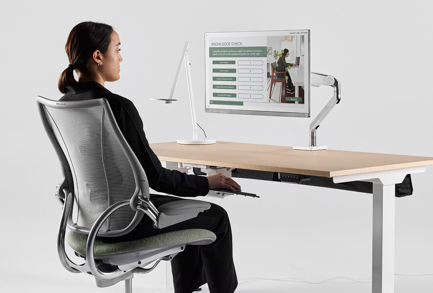 woman engaging in a ergonomics certification program on her workstation
