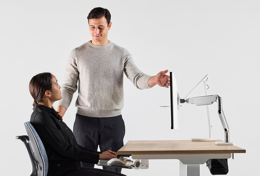 woman having her workstation monitor adjusted by ergonomist